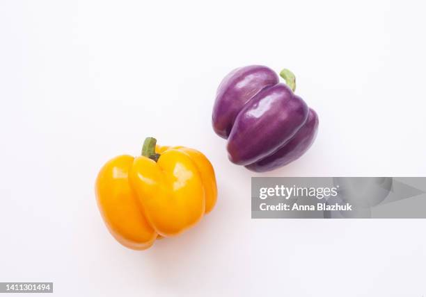 yellow and purple bell peppers on white background - paprika stock pictures, royalty-free photos & images
