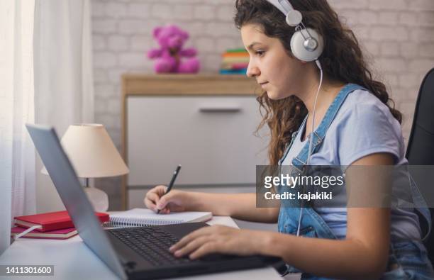 teen girl doing homework on her laptop - generation z covid stock pictures, royalty-free photos & images