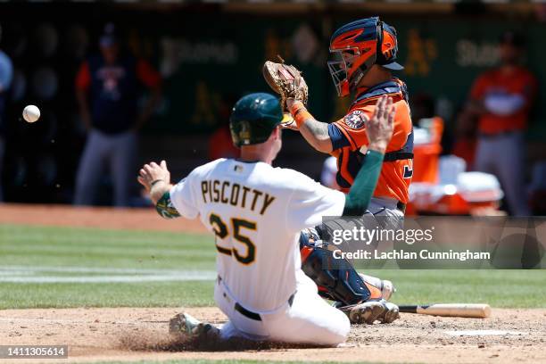 Stephen Piscotty of the Oakland Athletics slides in safe at home plate ahead of the tag by catcher Korey Lee of the Houston Astros to score on a...