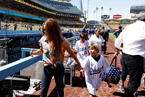 Singer Shakira walks off the field with her son, Sasha Mebarak, following a game between the Los Angeles Dodgers and the Washington Nationals at...