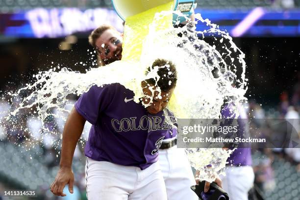 Charlie Blackmon of the Colorado Rockies dumps Powerade on his teammate Elias Diaz in his post match interview after hitting a 2 RBI walk off single...