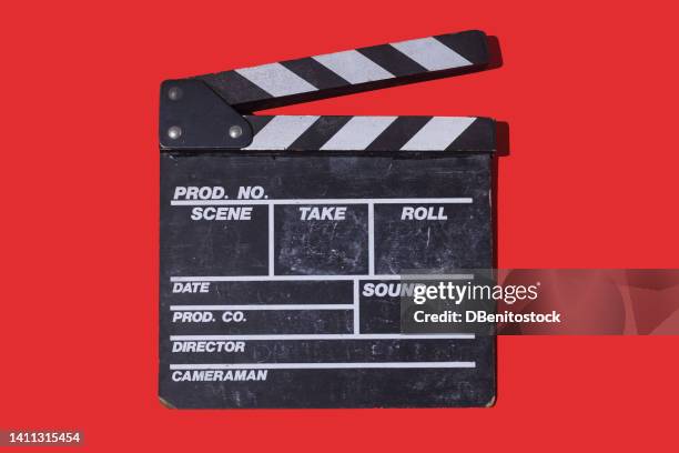 old wooden movie clapperboard with hard shadow on red background. concept of film industry, cinema, entertainment, and hollywood. - filmklappe stock-fotos und bilder