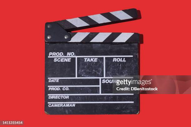 old wooden movie clapperboard with hard shadow on red background. concept of film industry, cinema, entertainment, and hollywood. - film screening fotografías e imágenes de stock