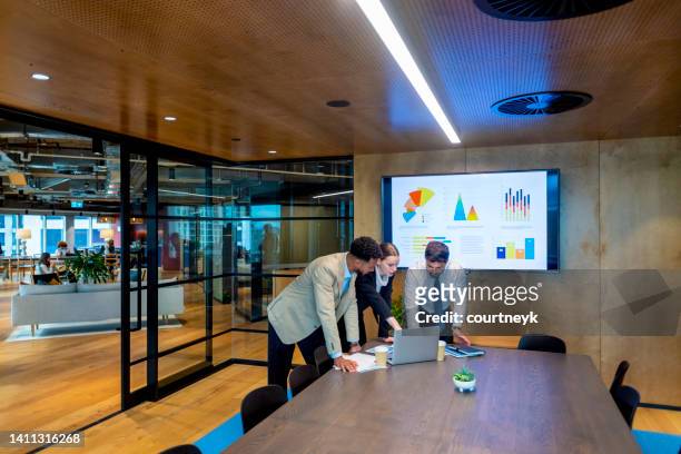 des gens d’affaires travaillant sur un ordinateur portable dans une salle de réunion de bureau moderne. - executive board meeting photos et images de collection