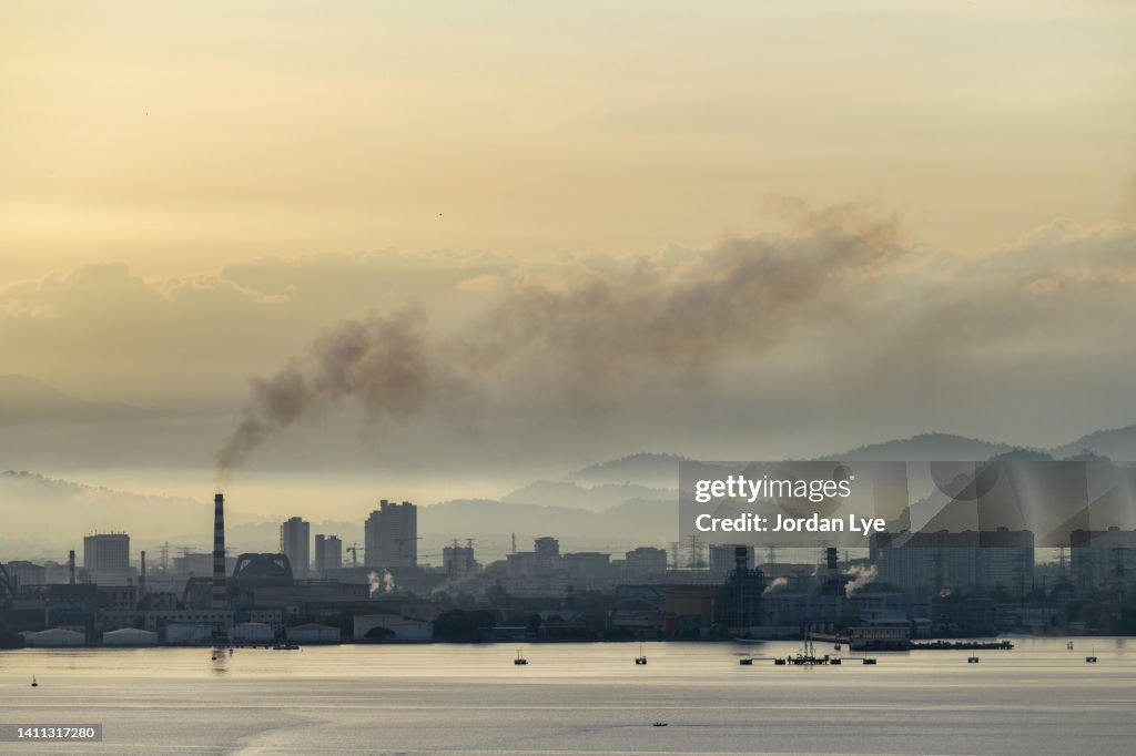 Smokestack emerging from fog in Industrial zone