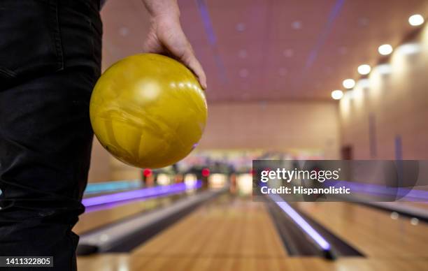 man bowling and holding a ball at the alley - bowling ball stock pictures, royalty-free photos & images