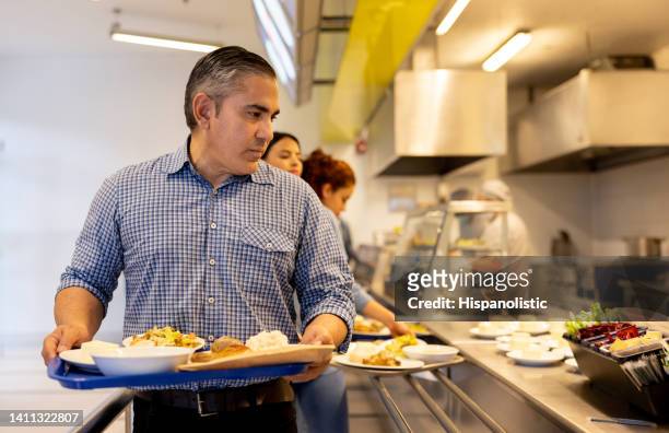 man eating at a buffet style restaurant - man tray food holding stockfoto's en -beelden