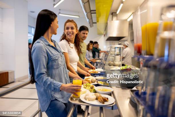 happy women eating at a buffet style cafeteria - cafeterias stock pictures, royalty-free photos & images