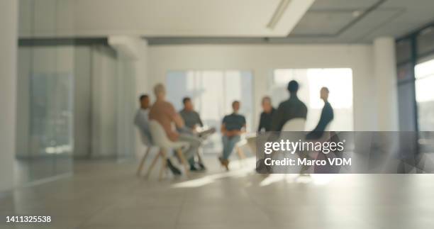 blurred people in group therapy session. addicts talking and sharing during physiotherapy while sitting on chairs in a community center or rehab. businesspeople doing team building or aa meeting - rehabilitation meeting stock pictures, royalty-free photos & images