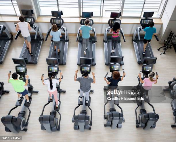 gruppe gesunder menschen, die im fitnessstudio trainieren - cross trainer stock-fotos und bilder