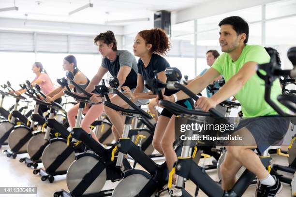 group of people exercising at the gym in a exercising class - spin class stock pictures, royalty-free photos & images