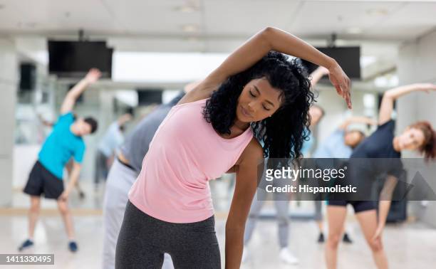 fitnesstrainer, der eine übungsstunde im fitnessstudio leitet - black female bodybuilder stock-fotos und bilder