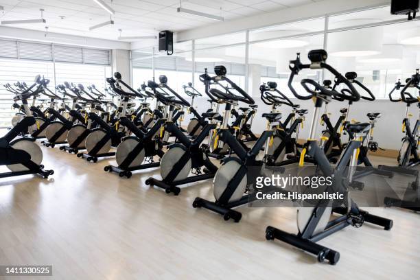 group of bicycles in a exercising classroom at the gym - cycling gym stock pictures, royalty-free photos & images