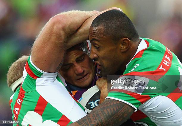 Cooper Cronk of the Storm is tackled by Michael Crocker and Roy Asotasi of the Rabbitohs during the round two NRL match between the Melbourne Storm...