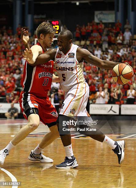 Jamar Wilson of the Taipans attempts to drive past Cameron Tovey of the Wildcats during the round 23 NBL match between the Perth Wildcats and the...