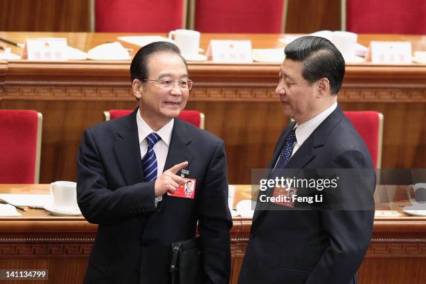 China's Premier Wen Jiabao talks to Vice President Xi Jinping as they leave after the fourth plenary meeting of the National People's Congress at The...