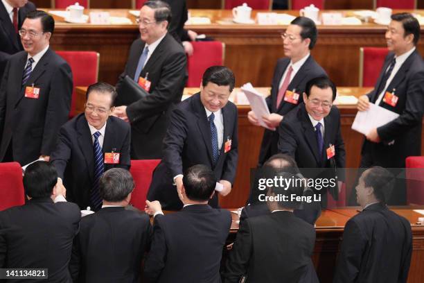 China's Premier Wen Jiabao , Vice President Xi Jinping shake hands with other delegates after the fourth plenary meeting of the National People's...