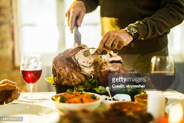 unrecognizable man carving turkey meat on thanksgiving. - cooked turkey white plate stockfoto's en -beelden