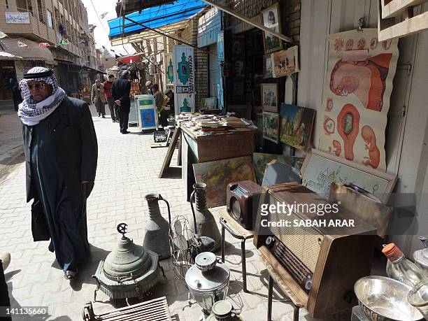 Man walks in the 300-year-old Souk al-Haraj in Midan Square in old Baghdad on March 11 where traders specialize in fixing old radios and other pre...