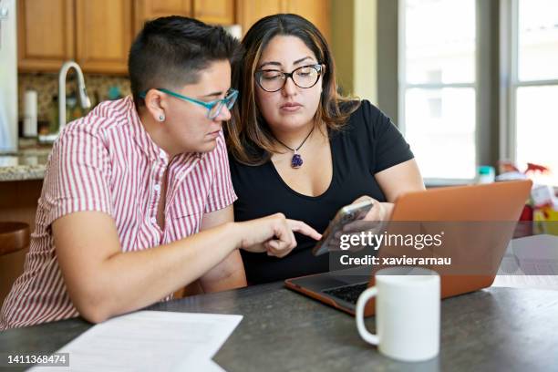 mid adult lesbian couple working on home finances - lesbian stock pictures, royalty-free photos & images