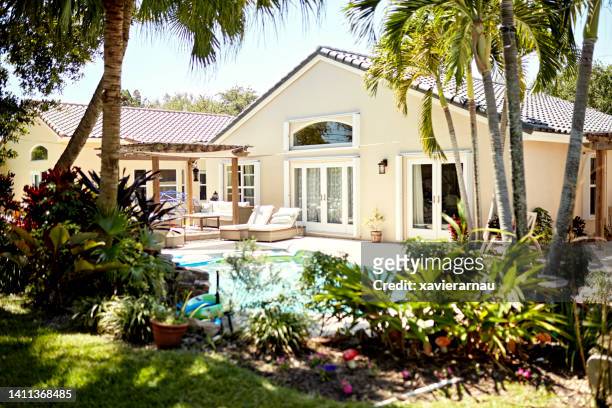 spanish-style home in sunny miami suburb - tropical garden stockfoto's en -beelden