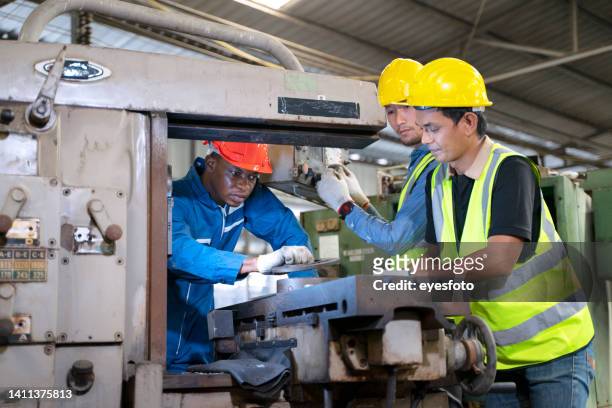 blue collar worker works with machine at factory. - bearings metal stock pictures, royalty-free photos & images