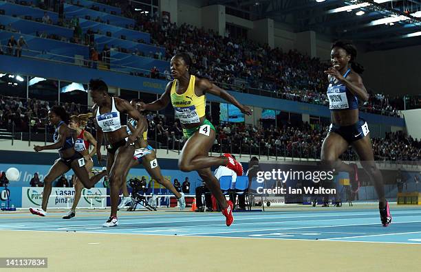 Veronica Campbell-Brown of Jamaica crosses the line to win gold ahead of silver medalist Murielle Ahoure of the Ivory Coast bronze medalist Tianna...