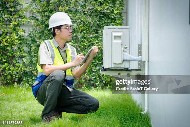 home inspector, repairman uses digital tablet to check air conditioners. - air conditioning technician stock pictures, royalty-free photos & images