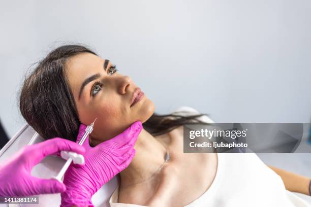 mujer joven en la clínica de tratamiento de belleza - mejilla fotografías e imágenes de stock