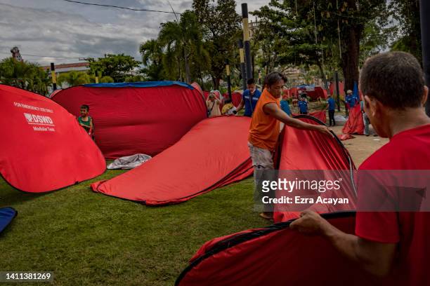 Residents set up tents at a park as precaution amid ongoing aftershocks, following a magnitude 7.0 earthquake on July 28, 2022 in Bangued, Abra...