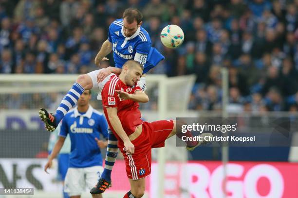Christoph Metzelder of Schalke and Mladen Petric of Hamburg go up for a header during the Bundesliga match between FC Schalke 04 and Hamburger SV at...