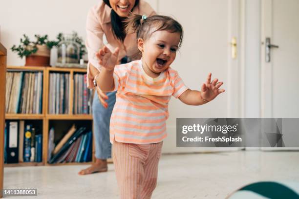 girl running from her mother while playing - baby run stock pictures, royalty-free photos & images