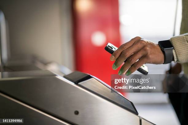 man using phone on scanner by entrance to city transport - entering turnstile stock pictures, royalty-free photos & images