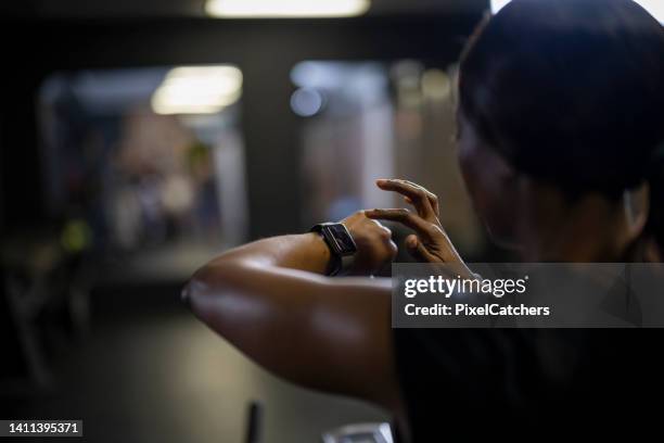 over shoulder woman using smart watch - peloton app stock pictures, royalty-free photos & images