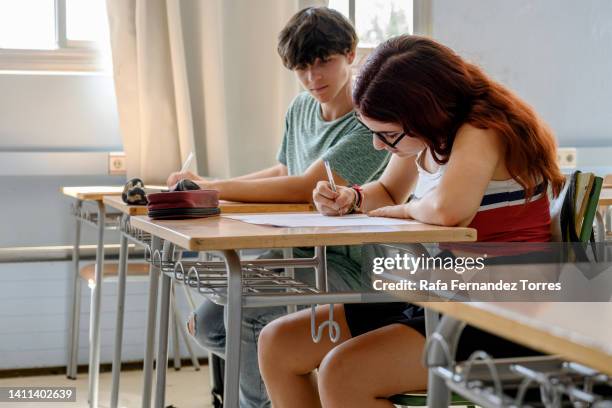 students taking written examination, man looking at man's paper - writing copy stock pictures, royalty-free photos & images