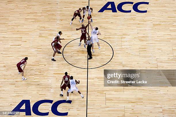 Bernard James of the Florida State Seminoles fights for control of the opening tip-off against Tyler Zeller of the North Carolina Tar Heels during...