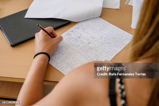top view of a female teacher in classroom grading homework - colorgrading stock-fotos und bilder