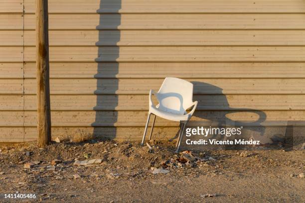 an abandoned plastic chair - deserción fotografías e imágenes de stock