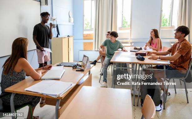 black teen student giving presentation in front of class - teacher in front of whiteboard stock pictures, royalty-free photos & images