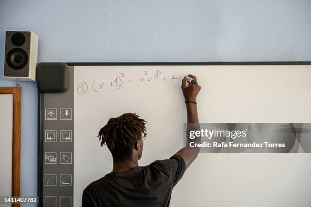 college student solving math problem - student in front of blackboard stock pictures, royalty-free photos & images