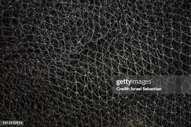 close-up of a used black fishing net - nylon stock-fotos und bilder
