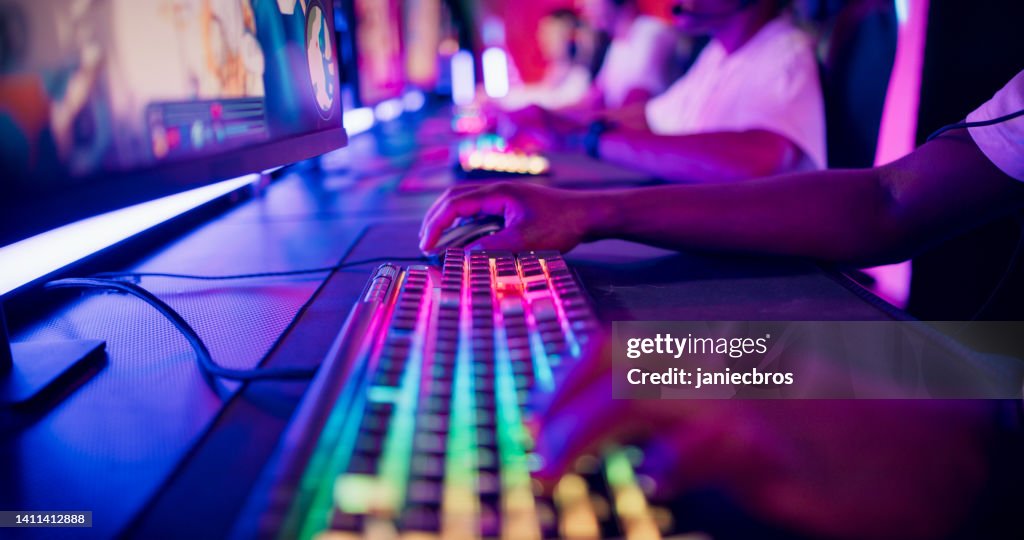 Close-up hand on a computer keyboard. Diverse pro gamer team with african ethnicity leader competing at video game eSport championship