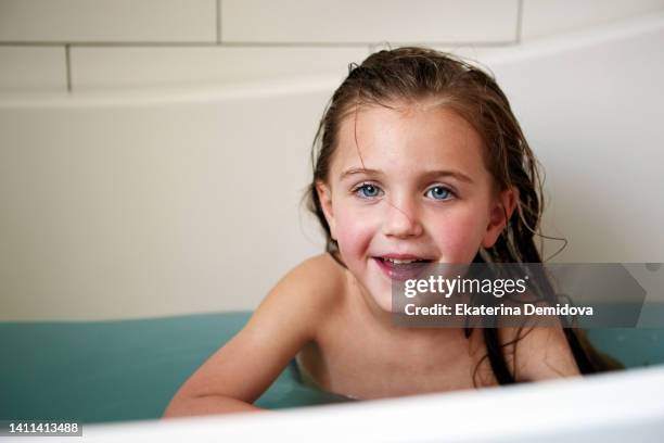 content girl sitting in bathtub - vuilnisman stockfoto's en -beelden