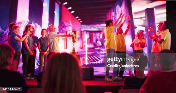 diverse yellow pro gamer team with african ethnicity players winning video game esport championship - awards broadcast stock pictures, royalty-free photos & images