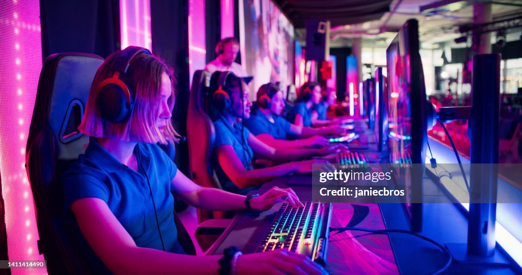 Vielfältiges blaues Pro-Gamer-Team mit weiblichen Spielern, die mit einem Trainer an der Videospiel-eSport-Meisterschaft teilnehmen
