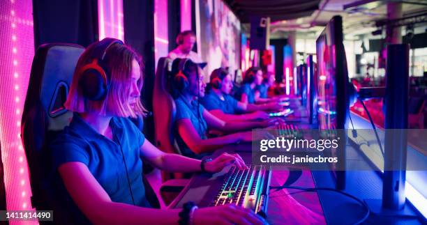 diverse blue pro gamer team with female players competing at video game esport championship with a coach - gaming championship stock pictures, royalty-free photos & images