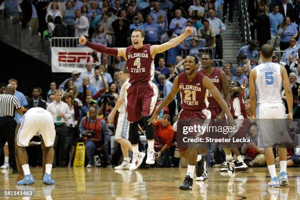 Deividas Dulkys and Michael Snaer of the Florida State Seminoles celebrate on court after they won 85-82 against the North Carolina Tar Heels during...