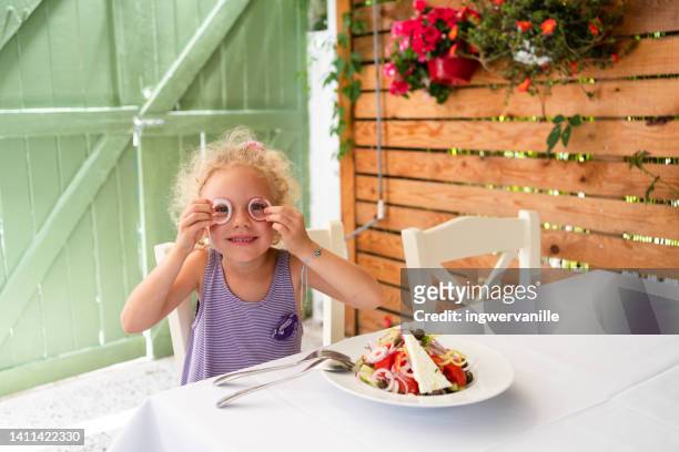girl holding onion rings in front of her eyes - greek salad stock pictures, royalty-free photos & images
