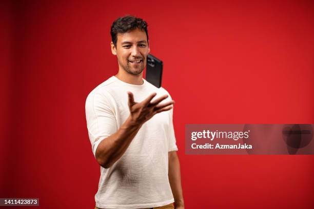 casually dressed asian man using his smartphone in studio - flick stock pictures, royalty-free photos & images