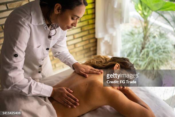 mujer recibiendo un mensaje en un spa - dar masajes fotografías e imágenes de stock